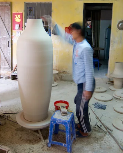 Xưởng Sản Xuất Gốm Sứ Bát Tràng Theo Yêu Cầu – Nhận Đơn Hàng Số Lượng Lớn Nghệ nhân chỉnh sửa tạo hình bình gốm Bát Tràng trên bàn xoay